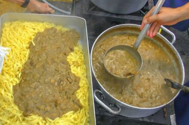 Cooking Huge Pans of Pasta with Mushrooms for Thousands of People. Italy Street Food Festival