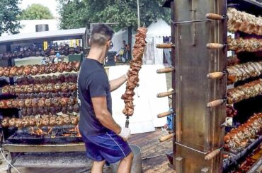 Huge Skewers with Pig Legs on Big Grills. Italy Street Food
