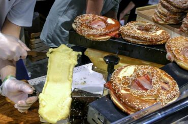 Huge Pretzel with Raclette Melted Cheese on Ham. Italy Street Food