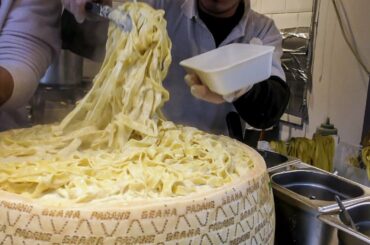 Hand Made Pasta Fettuccine Drowned in a Cheese Wheel. Italian Street Food in London Camden Town