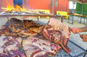 Argentinian Grill Master Roasts Huge Blocks of Bull Meat. Italy Street Food Festival