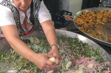 Two Women Master Huge Pans of Austrian Food. Italy Street Food Fair