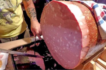 Hand Cutting Giant Mortadella and Ham. Italy Street Food