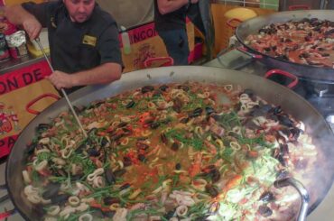 Many Huge Pans Cooking Spanish Paella. Street Food Fair in Italy