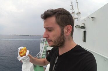 Eating arancini while crossing the Strait of Messina on a train in a boat