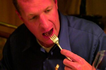 Close up of a man eating a bite of steak