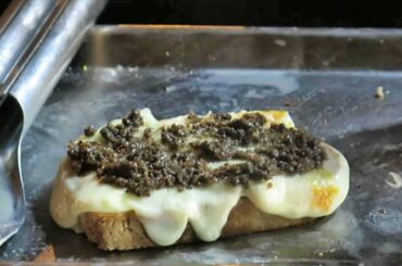 Italian Street Food. The Hanged Cheese Melted on Bruschetta with Truffle Cream