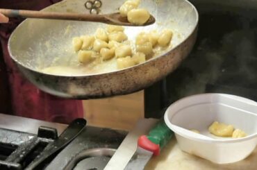 Italy Street Food from Aosta Valley. The Gnocchi Dumplings with Mocetta Sausage and Aromatic Butter