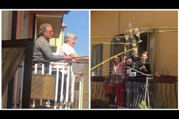 Neighbours in Italy have a wine party from balconies.