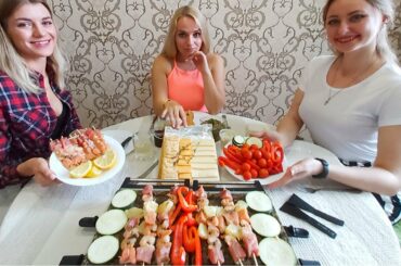 Russian Girls Eating Swiss Raclette. Melted Cheese over Grilled Meat