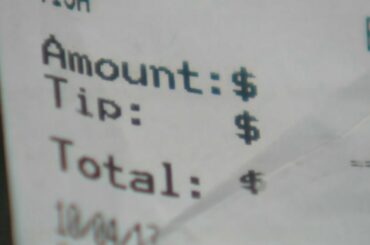 A server at a north Phoenix restaurant says she was fired for speaking out against a new tipping