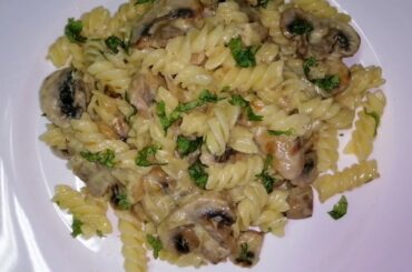 Fusilli pasta in creamy mushrooms sauce. Delicious Italian recipe.