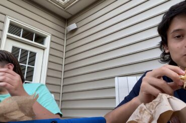 A fat kid and Italian kid stare blankly into the camera while eating Big Macs