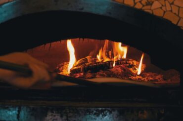 cooking pizza in an italian woodfired clay oven in 5RADUSW