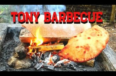 Cooking Italian Calzone in the forest - barbecue using clay tiles.