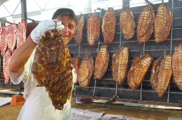 Huge Pyramidal Grills of Ribs, Argentinian Asado, Cheese on Meat. Italy Street Food Festival