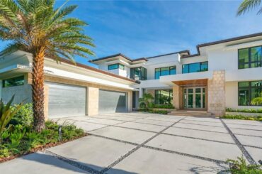 A Sophisticated Resort Like Oasis in Pinecrest, Florida features a grand foyer with a sweeping stair
