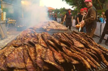 Italy Street Food. Melted Cheese on Pretzel, Huge Grill of Ribs, Pork Meat for Sandwich, more Food