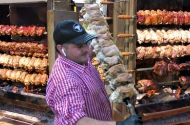 Germany Street Food in Italy. Huge Grills with Pork Legs Skewers, Burgers, Sausages. Sud Tirol