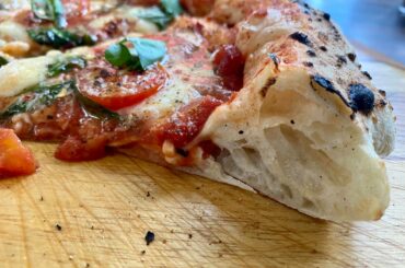 Pizza with fresh tomatoes, basil, mozzarella, parmigiana, cracked pepper and crushed red pepper and olive oil.