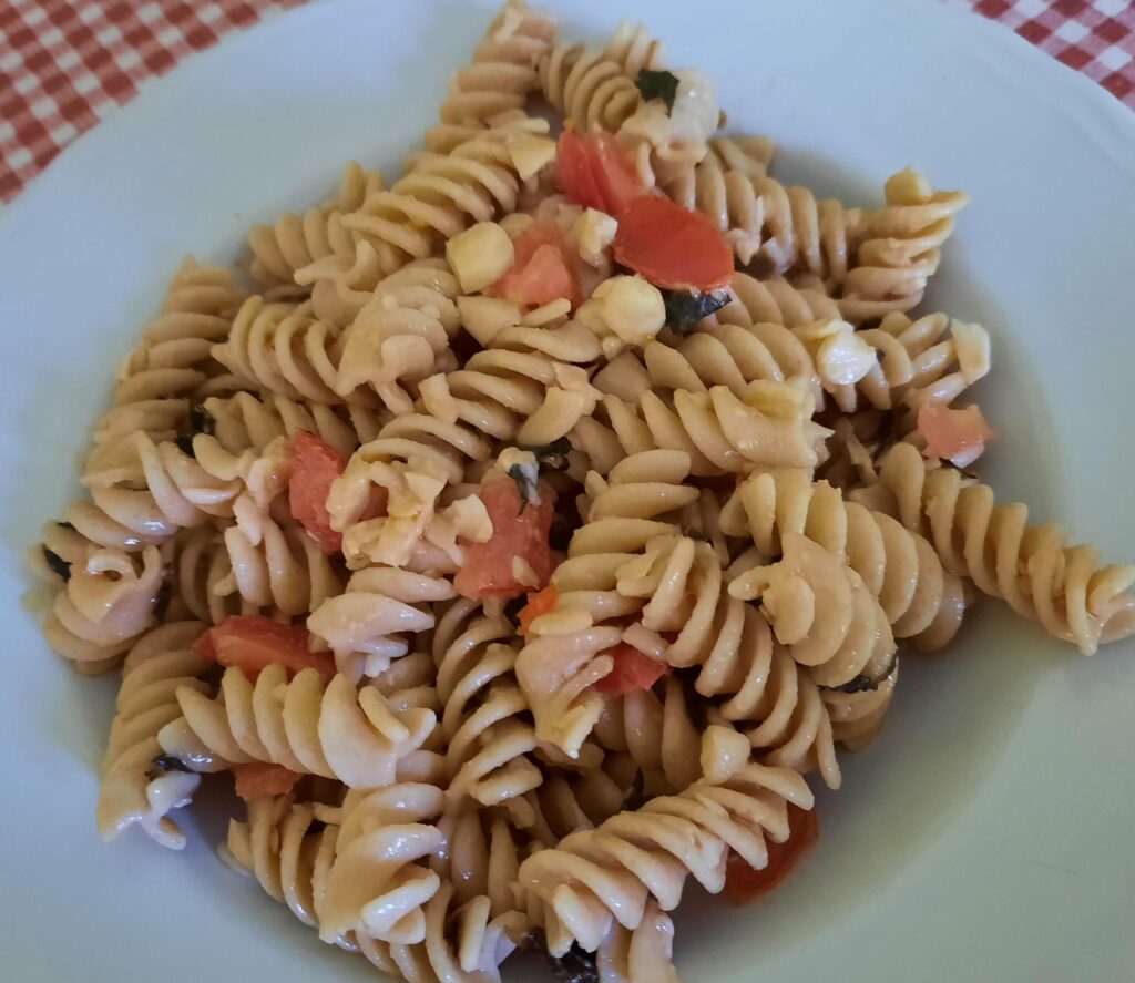 cold and light pasta with tomato, chopped almonds, flaked pecorino cheese and chopped fresh mint