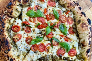 Basil pesto base pizza with tomatoes, garlic, basil.