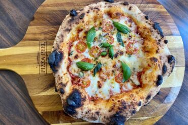 Neapolitan pizza with San Marzano tomatoes, basil, garlic, Parmesan and mozzarella cheese, fresh garden cherry tomatoes