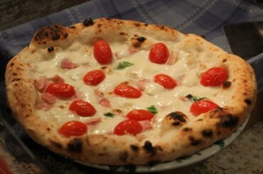 Pizza with datterini tomatoes, cooked ham and fresh mozzarella