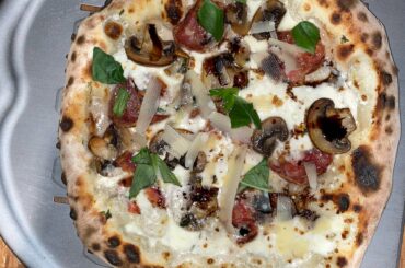 White pizza with roasted mushrooms and a locally made salami.
