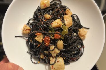 Squid ink pasta with light tomato sauce, pepperoncino and scallops