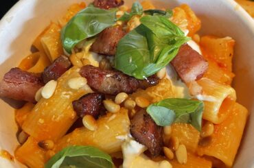 Tomato and Bell pepper pasta with crispy guanciale, basil, roasted pine nuts topped with Burrata