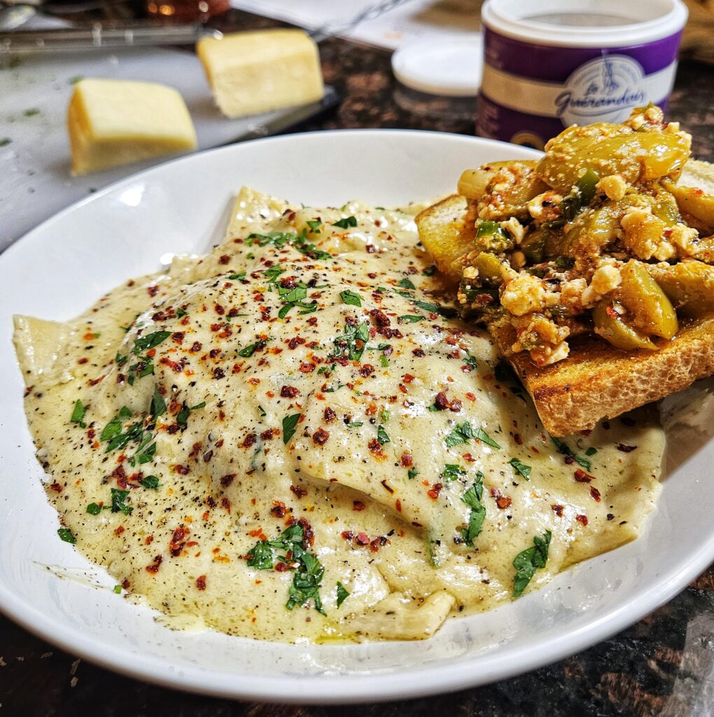 5 cheese ravioli with cacio e pepe inspired sauce, and grilled sourdough with crushed olives, feta, charred scallions and Aleppo pepper.