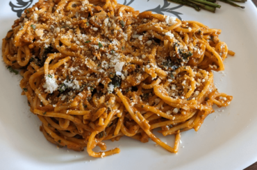 Spaghetti with tomato sauce with a side of asparagus