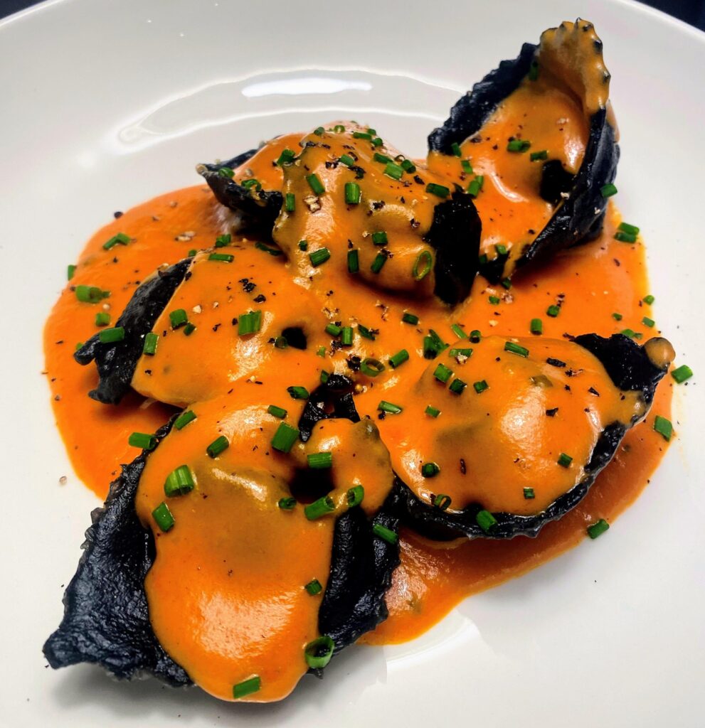 Squid ink lobster tortelloni in a bisque sauce