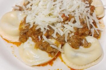 Ham and cheese sorrentinos, with bolognese sauce and lots of cheese
