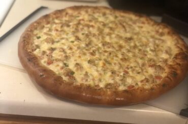 Alfredo sauce pizza with tomatoes, green onions and chicken.