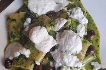 Pasta with rucola pesto, ricotta cream and olives
