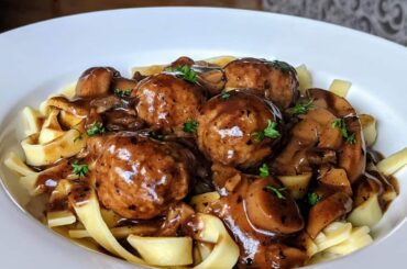 Homemade fettuccine with meatballs and gravy.