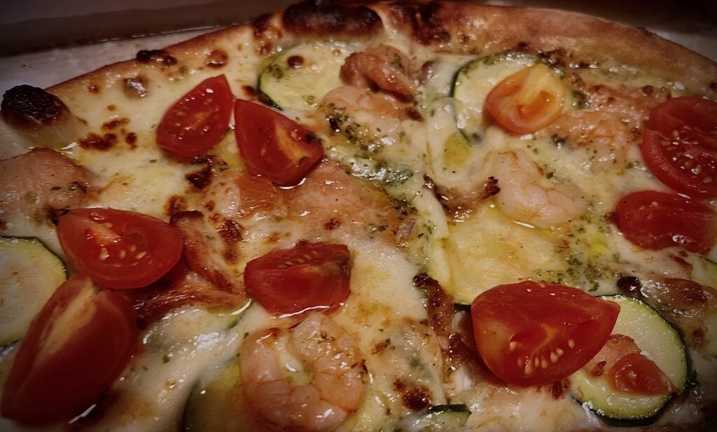 Seafood pizza (shrimps, salmon, zucchini, pomodorini and garlic oil)