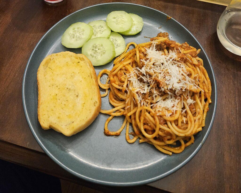 Spaghetti with meat sauce, garlic bread, and sliced cucumber!🤤