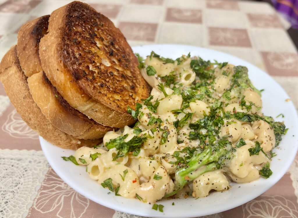 Confit garlic macaroni with Alfredo sauce, sautéed mushroom, broccoli with some garlic bread