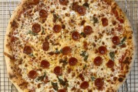 Homemade pizza. Pepperoni and basil under cheese