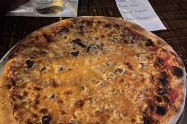 Basil, olives, and balsamic drizzle under the cheese layer