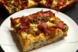 Homemade Detroit pizza with pepperoni, peppers, and pesto