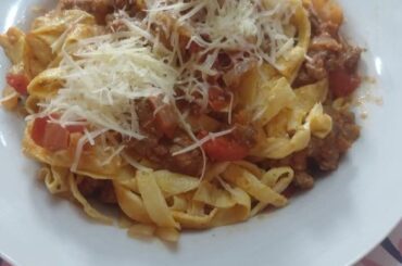 Homemade pasta with Bolognese sauce and grated cheese