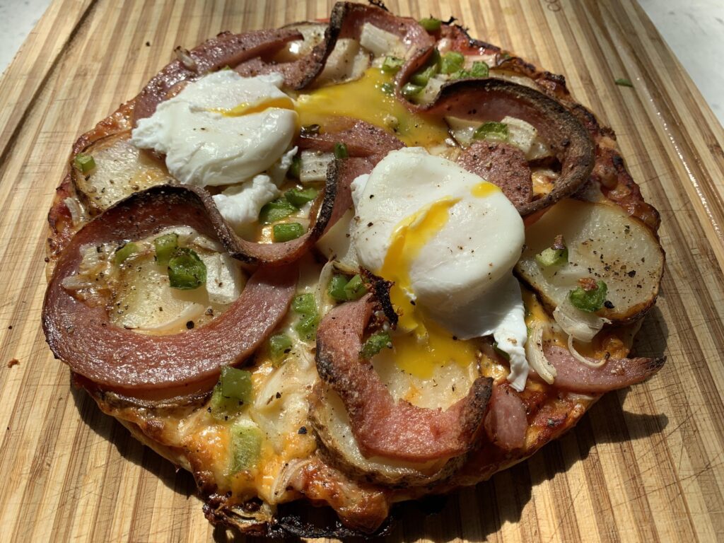 Breakfast Pizza with pork roll, poached eggs, potatoes,peppers,onions