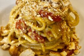 Spaghetti with zucchini pesto, baked tomatoes, and crumbled Apulian taralli.