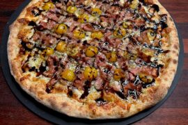 Homemade mortadella, pesto, cherry tomatoes, and balsamic reduction