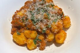 Homemade gnocchi in red bell pepper sauce with sausage