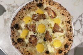 Pizza carbonara. mozzarella fior di latte, guanciale, pecorino, black pepper & egg yolk pecorino emulsiony thing